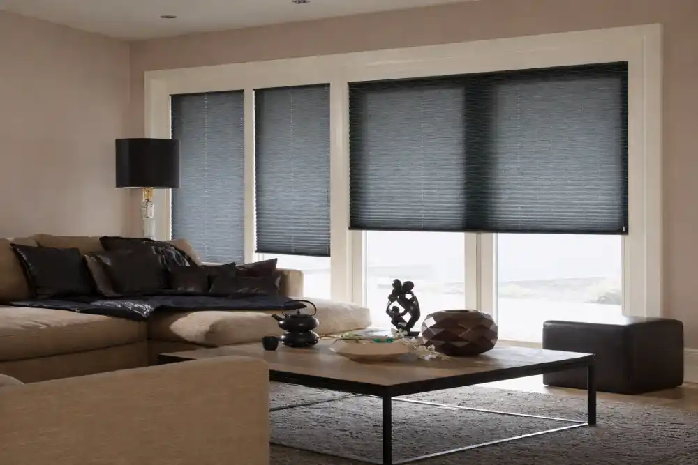 Geniş camlı, koyu gri plise perdeli modern salon iç tasarımı.